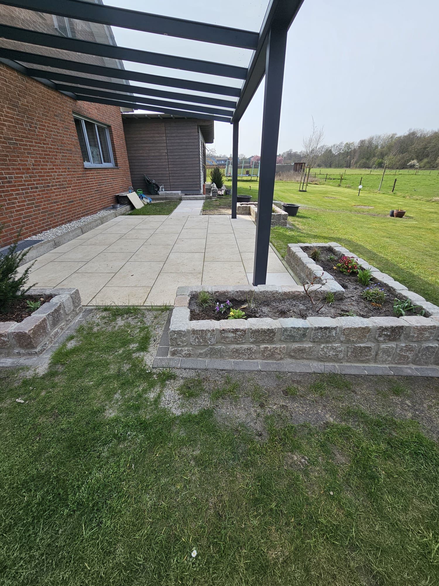 Überdachte Terrasse mit angrenzendem Garten